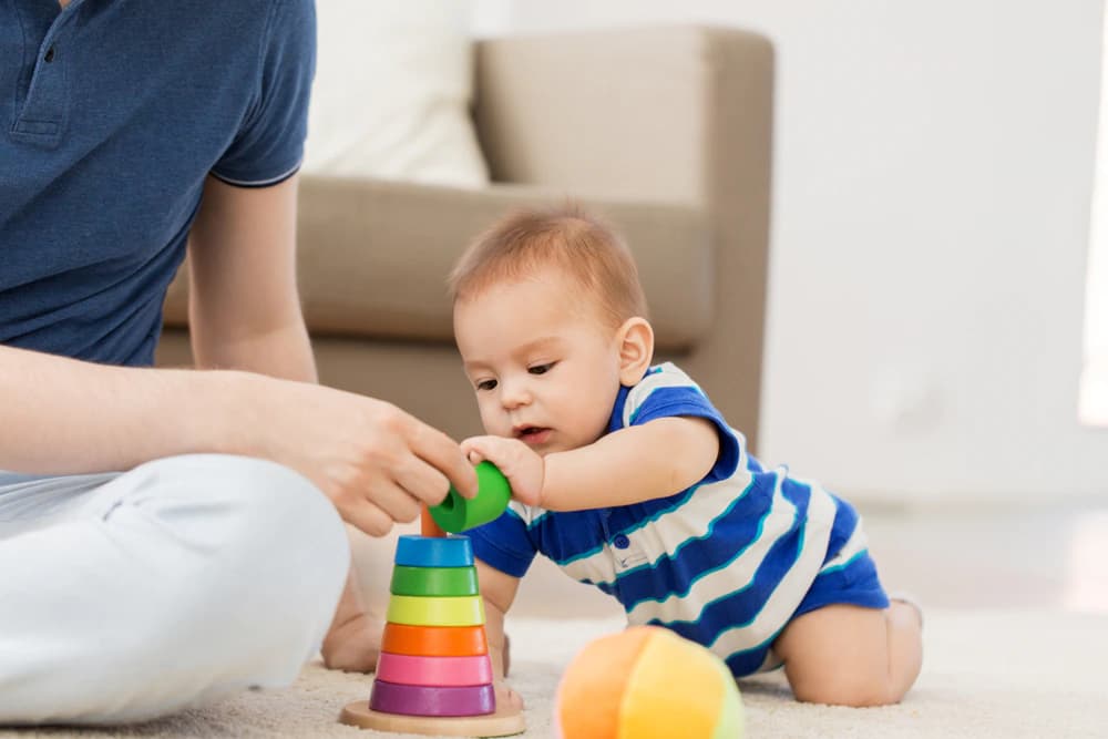 ilk adım öncesi motor beceresini oyuncak piramidi ile geliştiren erkek bebek