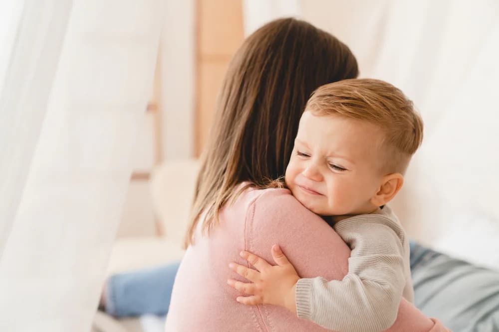 Ağlayan küçük çocuğunu kucağına alarak sakinleştiren anne